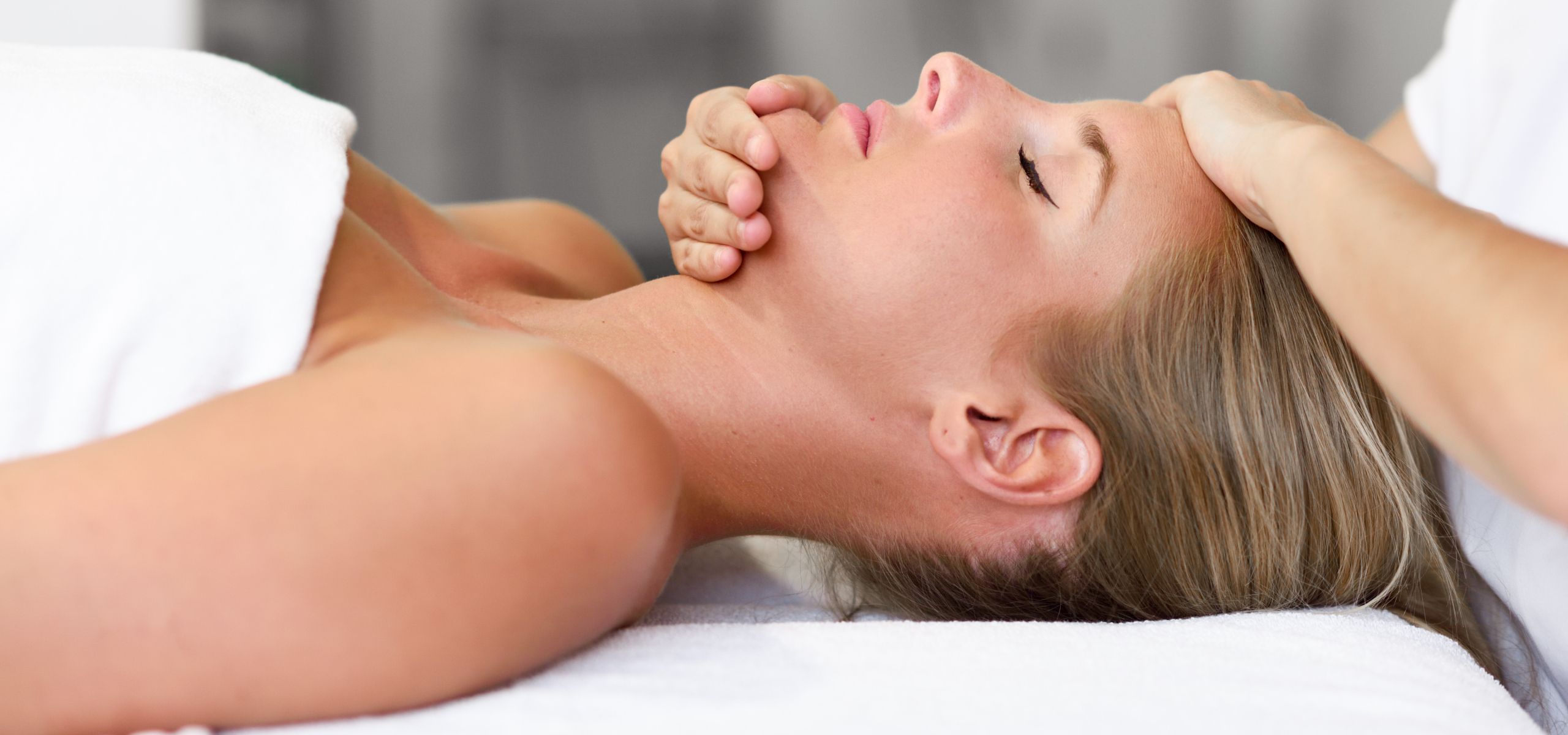 Young woman receiving a head massage in a spa center.